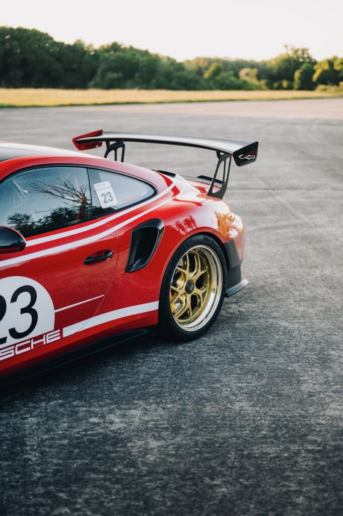 A red porsche sports car with the number 23.