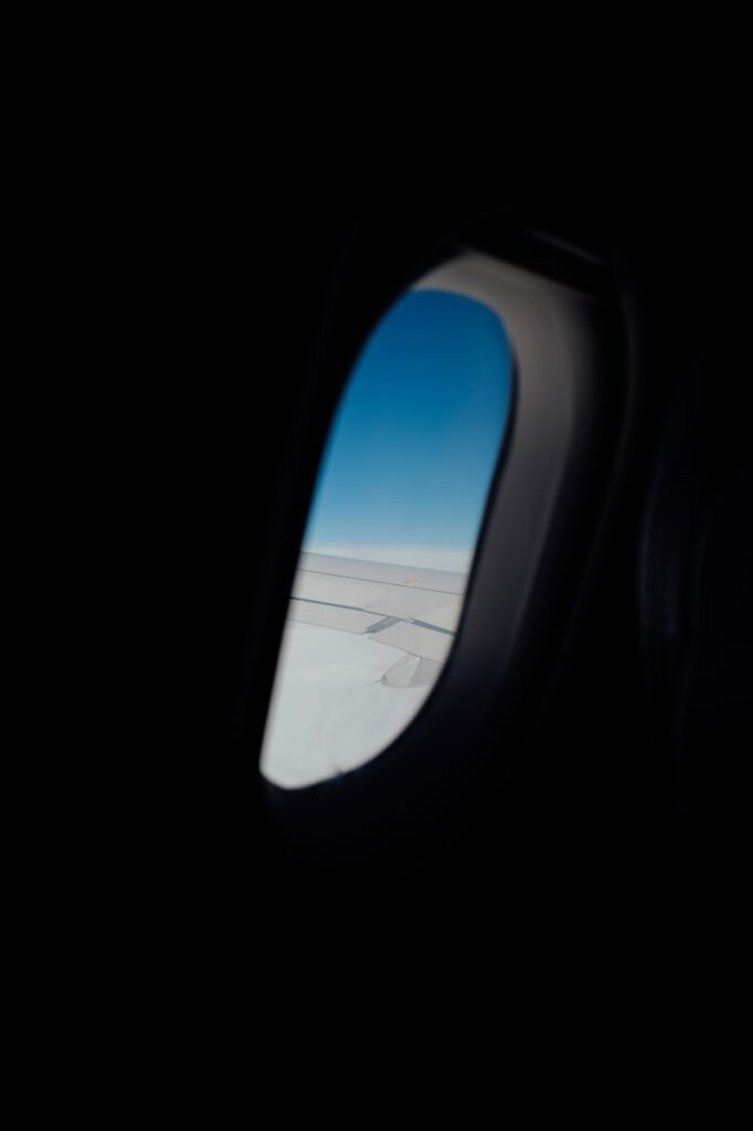 Airplane window view of the sky and clouds.